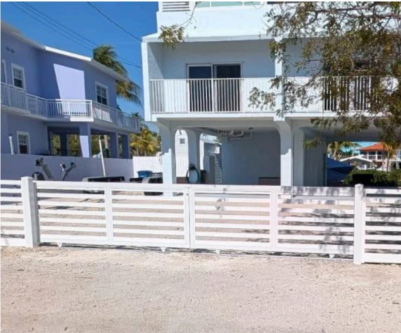 Premium white PVC horizontal-slat rolling gate installation at a coastal Southeast Florida home - Elite PVC