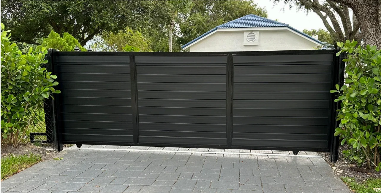 Black aluminum horizontal-slat rolling gate on a paver driveway in Southeast Florida - Elite PVC